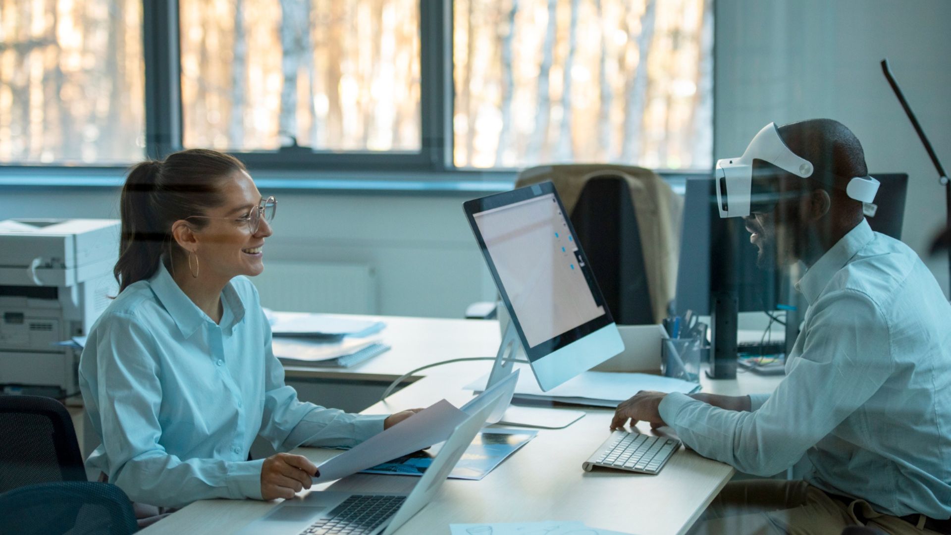 Kollegen besprechen Projektfortschritte vor einem Bildschirm in einem Büro.